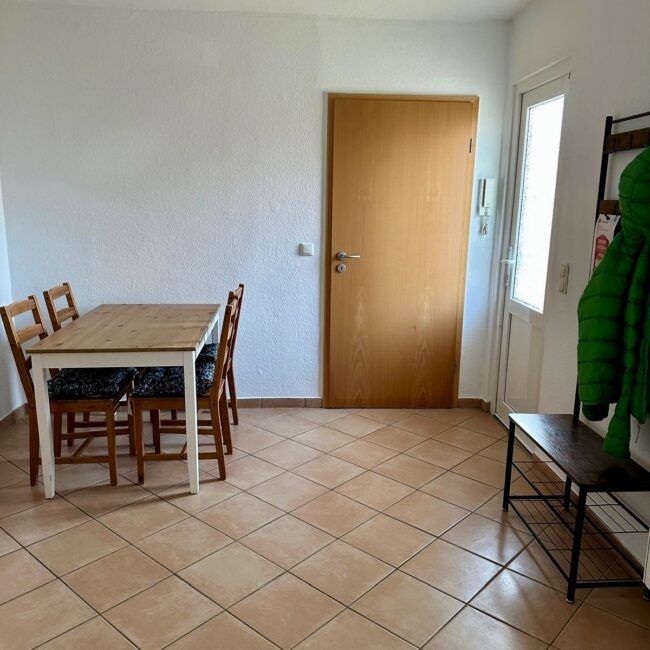 Ein Esstisch und eine Garederobe in einem Zimmer des betreuten Wohnens von Neue Wege.